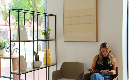Mujer en sillón leyendo sobre estantería
